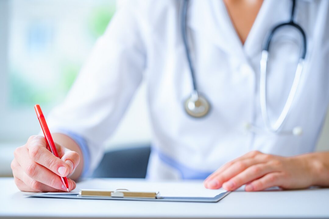 A Doctor With A Stethoscope Writing Diagnosis And Therapy Of The