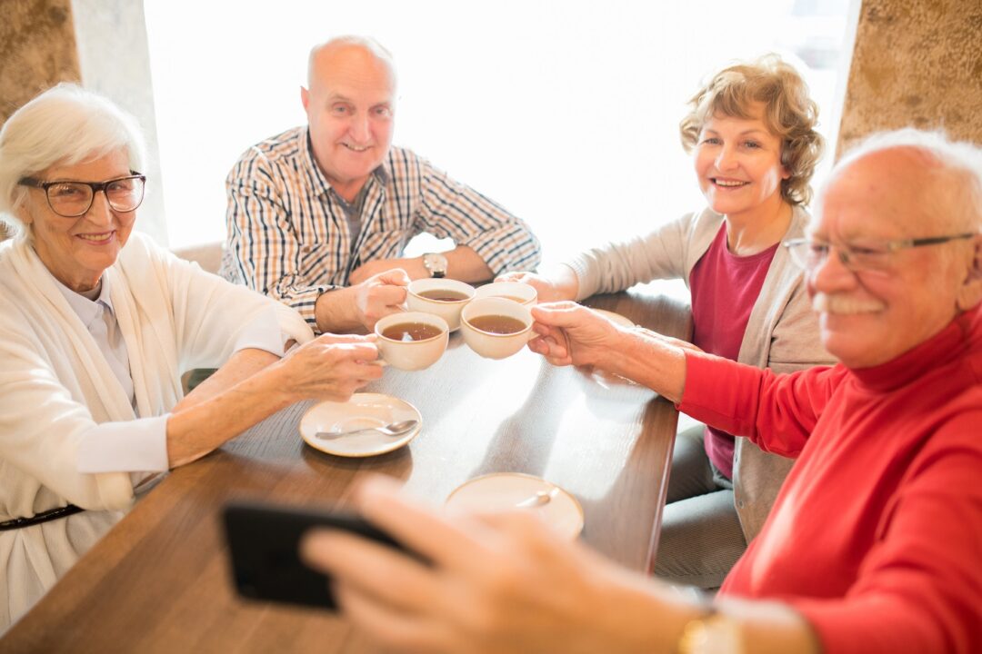 Cheerful Seniors Photographing Together While Drinking Tea