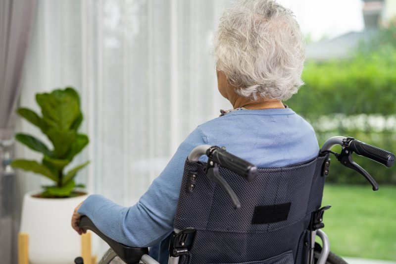 An Elderly Woman Sitting On Wheelchair Looking Out The Window For Waiting Someone Sadly Melancholy And Depressed Scaled E1670412096977