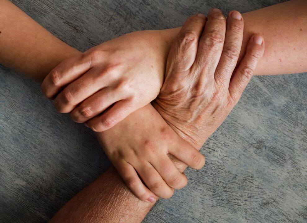 Close Up High Angle View People Holding Hands Table
