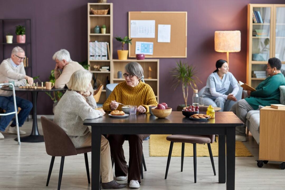 Common Room Retirement Home With Seniors Enjoying Leisure Activities