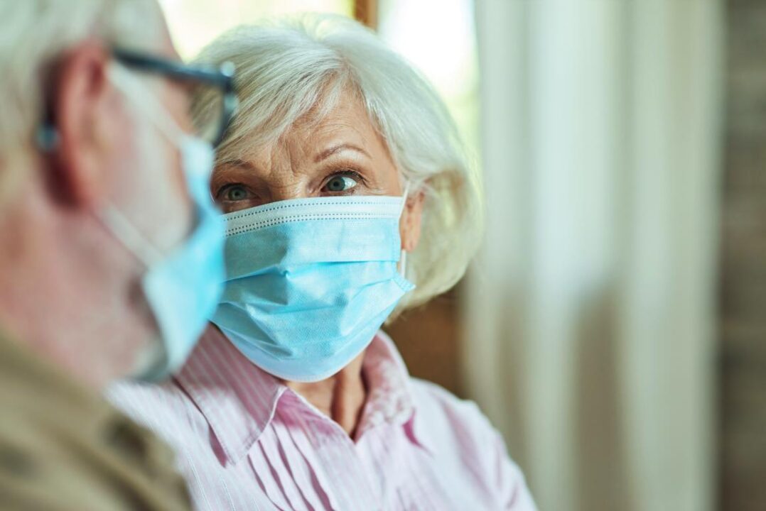 Elderly Couple In Masks Looking Each Other