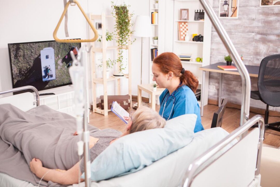 Female Doctor Nursing Home With Senior Woman Watching Tv