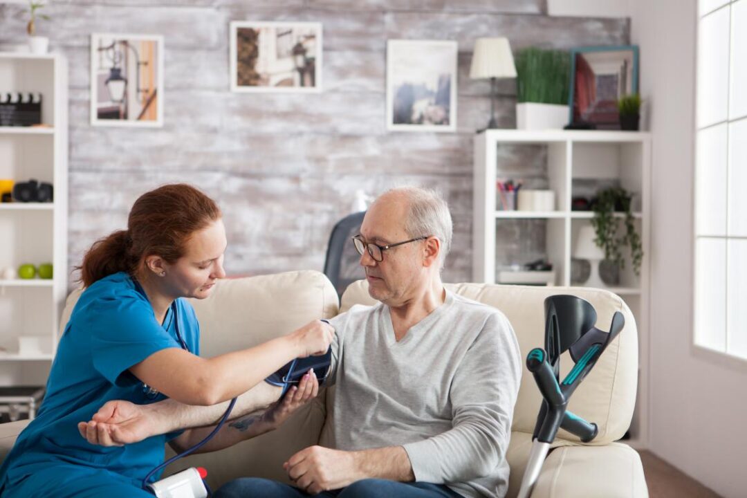 Female Nurse Attaching Digital Device Old Mans Arm Check Blood Pressure