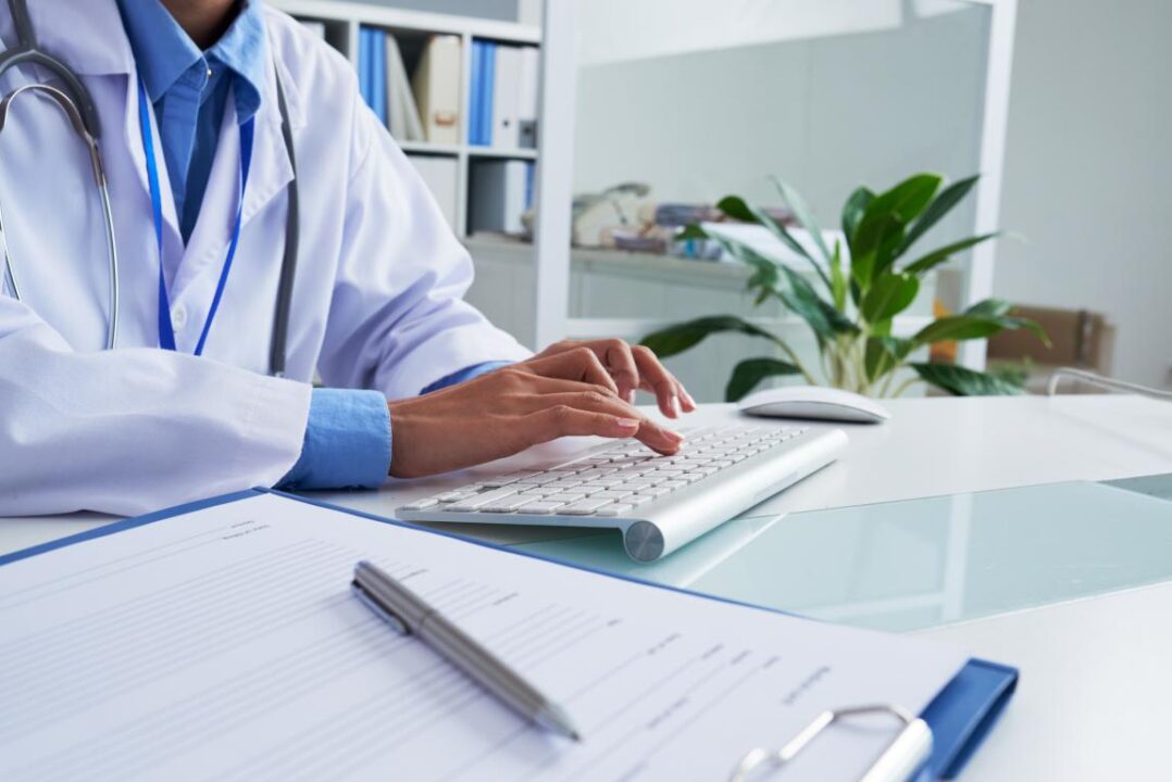 Hands Of Unrecognizable Female Doctor Typing On Keyboard In Office