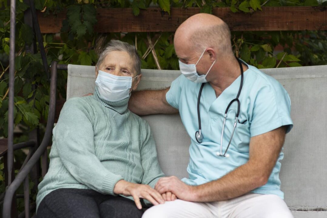 Male Nurse In Swing Chair With Senior Woman