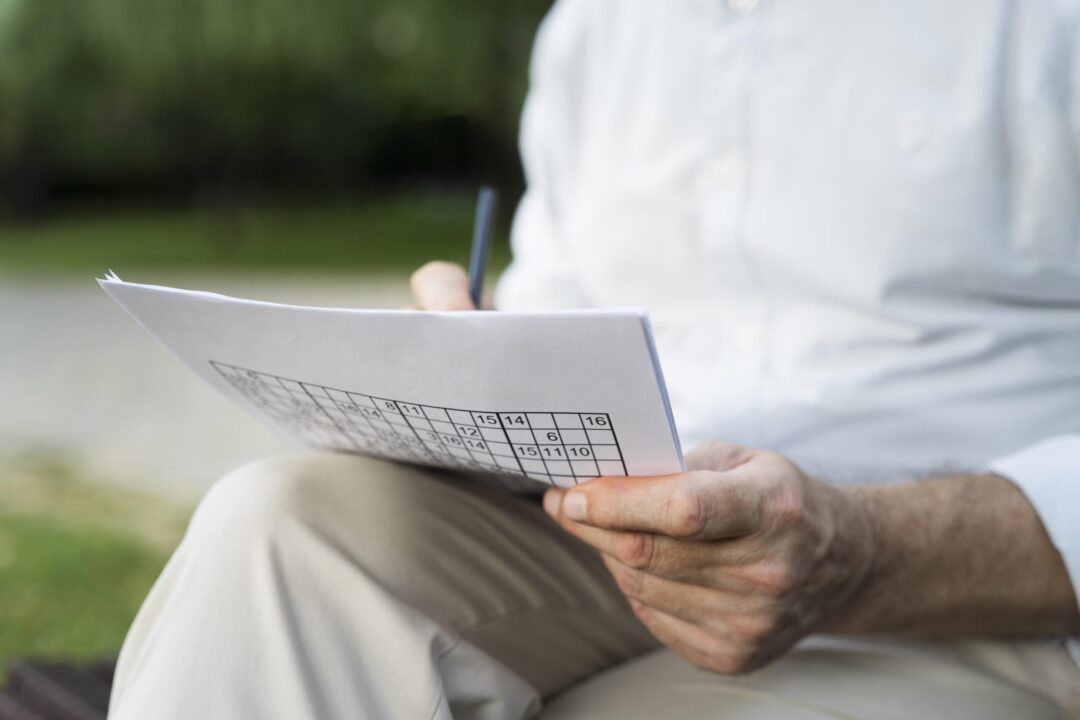 man-enjoying-sudoku-game-paper-by-himself-scaled