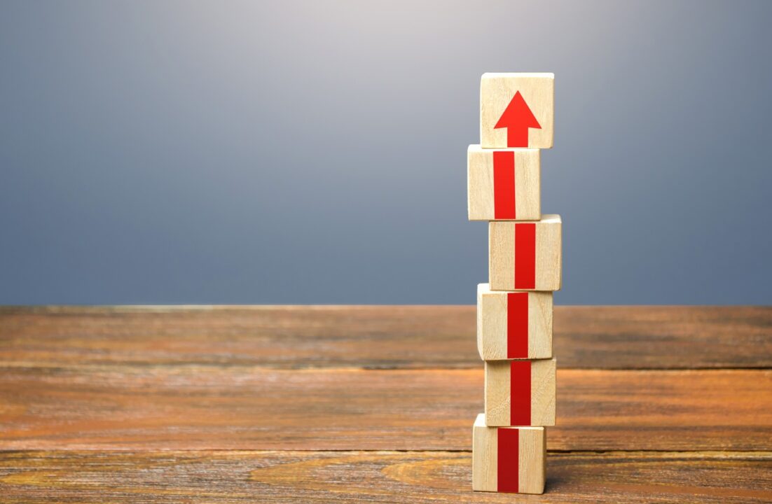 Block Tower With Red Arrows. Growth, Development And Progress Concept. Career Promotion Step By Step. Education, Learning. Reaching A New Level. Improving Skills.