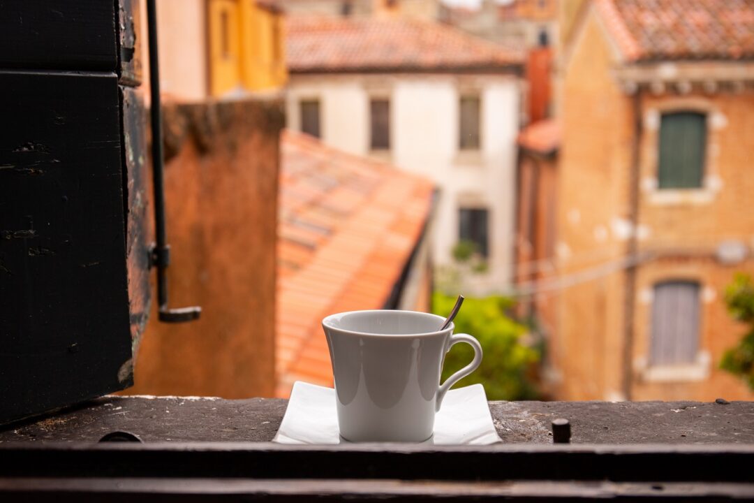 View From Window On City With Cup Of Coffee Of Windowsill In Venice, Italy.