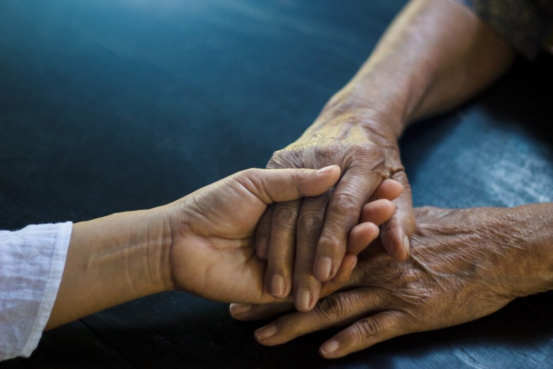 Daughter Holding Hand Of Mother Elderly That Is Alzheimer And Pa